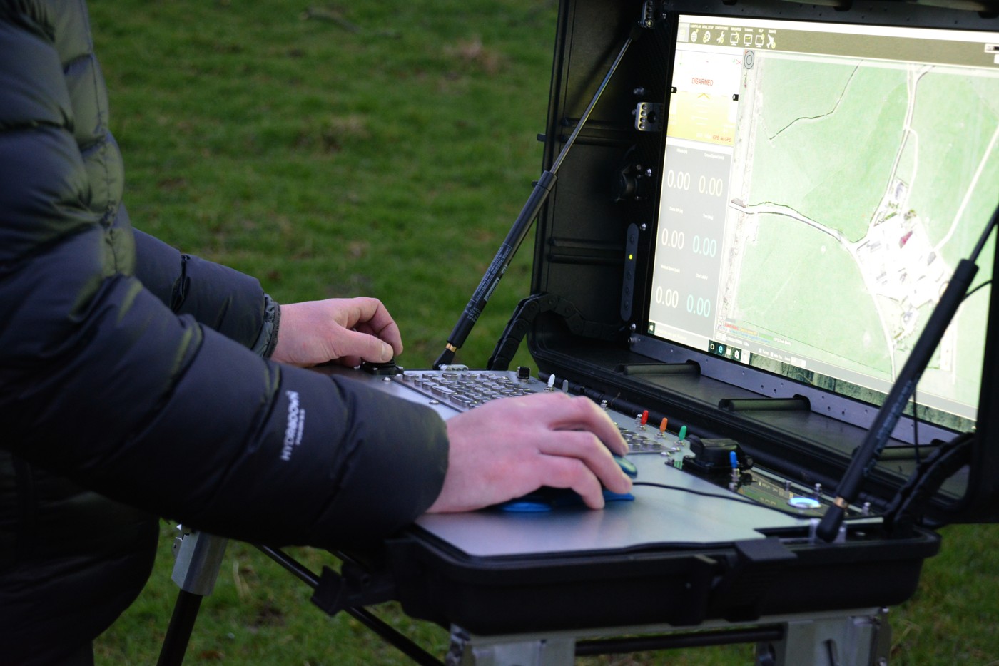 Operator using a portable Wing GCS drone ground-control station with map display and flight controls