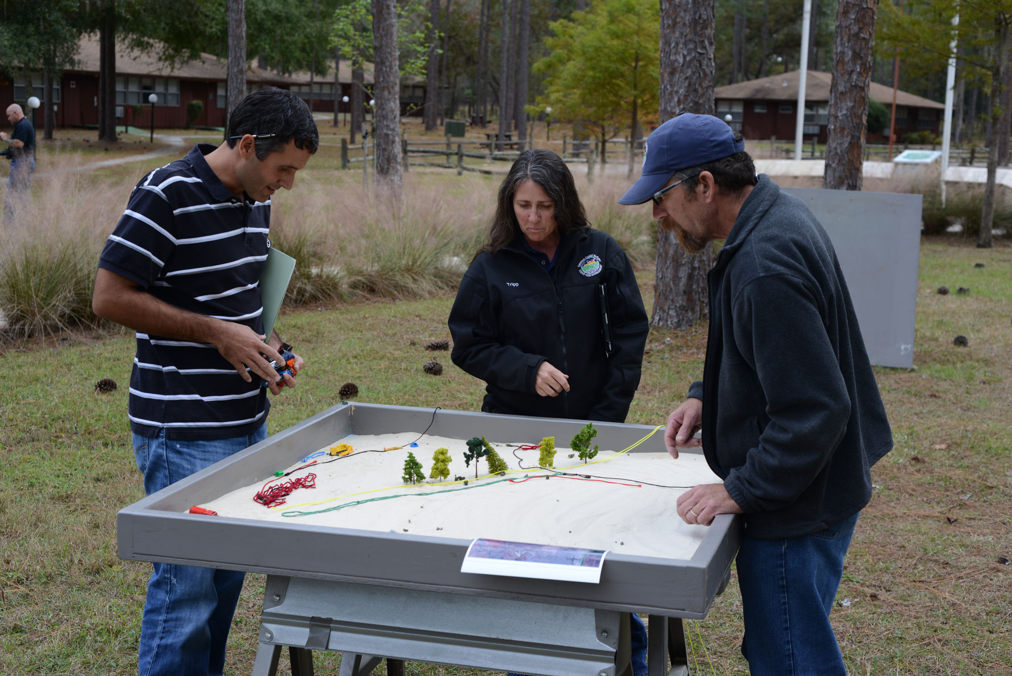 Participants planning prescribed-burn operations around a physical sand table